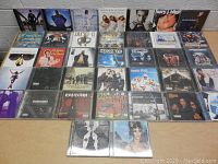 37 Rap and R&B CDs laid out on table in a grid, showing front covers from multiple artists including Eminem, Prince, and Snoop Dogg.