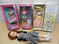 All four dolls shown together, three in original boxes and one loose doll.