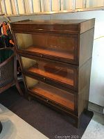 Front view of assembled barrister bookcase showing three stacked glass-front compartments and an open top shelf