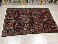 Full view of red and black Antique Bakhtiar rug laid flat on tile floor