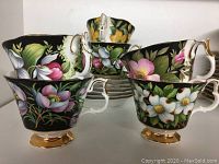 Four Royal Albert teacups front view showing floral patterns and gilt bases