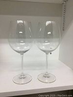 Two clear red wine glasses with tall stems side by side