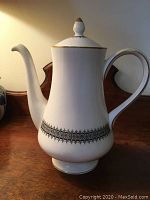 White Wedgwood coffee pot on wooden surface, shows side profile