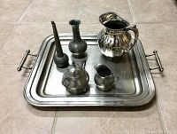 Metal tray holding various antique items: two pewter flower pots, pewter sugar bowl, pewter milk jug, and silver water jug