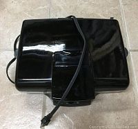 Closed view of black Hamilton Beach electric grill, top and power cord visible