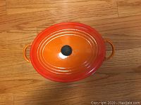 Top view of orange oval Dutch oven with lid in place