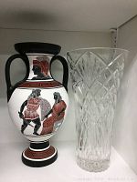 Photo of crystal vase and Greek amphora together on white shelf
