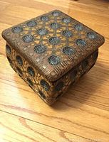 Closed ornamental wooden jewelry box with carved floral and geometric inlay design on lid and sides.