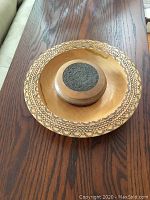 Large wooden plate with detailed border designs showing clear wood grain and patterns.