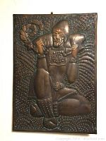 Hammered metal picture of kneeling male Oriental figure with detailed embossed patterns