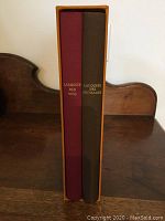 Two hardcover books in slipcase, titles Larousse des vins (burgundy) and Larousse des fromages (dark cover) seen on spine.