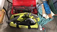 Overview image showing Ryobi power tools in branded bag, hand saws in red case, blue and teal rope coils, cable lock.
