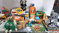 Overview of the lot showing the vintage Fisher Price zoo toys including the cash register, wooden snake, various animal figures, and plush toys.