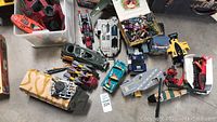 Wide view of various toy vehicles and figurines including tanks, cars, and plane