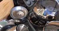 Photo showing multiple large pots, pans, waffle maker, cupcake liners, and kitchen utensils in a pile