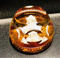 Top and angle view showing engraving of King Charlemagne's portrait inside amber-colored crystal with multiple sides.