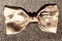 Front view of a large sterling silver bow tie shaped pin with a polished surface and folds mimicking fabric.