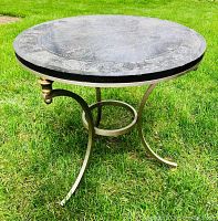 Assembled table on lawn showing marble top and metal base