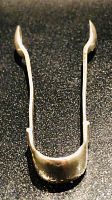 Top view of the sugar tongs highlighting the full length and structure, showing the uniform polish and slight bends for ease of use.