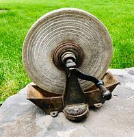 Front view of the grinding wheel showing the stone surface and cast iron base with crank handle
