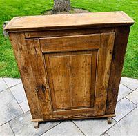 Full view of the front of the antique wood cupboard showing door and frame details.