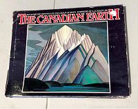 Front cover of the hardcover book with dust jacket, featuring a stylized mountain painting and visible wear on the black dust jacket.