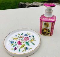 Minton plate and painted porcelain dresser jar displayed together on white surface outdoors.