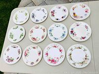 Overview photo of all 12 Royal Albert luncheon month plates arranged on a table, showing each plate's floral design and month name.