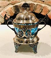 Front view showing ornate handles and silver and blue glass contrast.