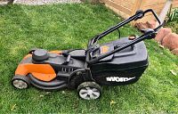 Side profile view of mower body, deck, wheels and bag