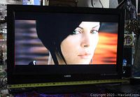 Front view of Vizio 31-inch HD TV powered on displaying a close-up of a woman's face, showing screen clarity and condition.