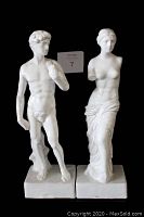 Full view of both Venus de Milo and David white porcelain statues standing side by side on black background