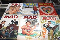 Top view of six MAD magazines laid out to show the colorful and humorous covers from different years.