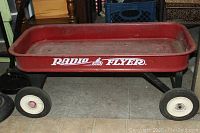 Side view of the classic red metal Radio Flyer wagon showing the logo and wheels