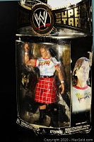 Photo showing full front view of sealed Rowdy Roddy Piper figure in packaging with WWE branding and accessory items visible.
