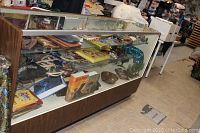 Front view of the glass display case showing wood base and glass top with merchandise inside (not included).