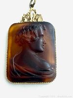 Close-up of the front of the cameo pendant showing the detailed profile relief and gold-tone frame.