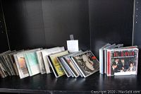 Photo showing several assorted music CDs standing and leaning against a black background, including an Il Divo Greatest Collection album visible on the right.