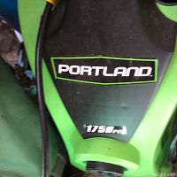 Close-up photo of the Portland brand logo and 1750 PSI rating on the green and black electric power washer.