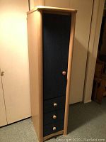 Front view of tall wooden dresser locker with blue door and four drawers.