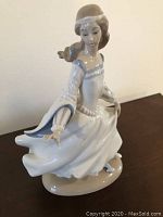 Side and front views of the woman figurine, showing detailed dress and pose.