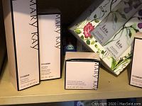 Photo showing multiple boxed Mary Kay Timewise items including cleanser, moisturizer, and a small jar product, plus a floral box labeled 'Iris'.