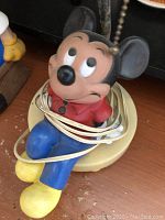 Vintage Mickey Mouse lamp with cord wrapped around the figure showing lamp base and colorful paint.