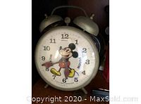 Full front view of the clock showing dial with Mickey Mouse figure and twin bells on top