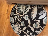 Round accent rug with floral pattern and black background