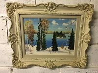 Full view of the vintage ornate framed painting showing a snowy lakeside scene with trees and lake island.