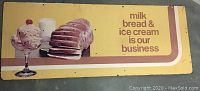 Full view of rectangular vintage sign with three food images and advertising text on yellow background.