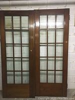 Photo of both wooden French doors with glass panels, showing overall condition and size.