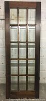 Full front view of vintage French door showing wood frame and all 15 beveled glass panels.