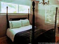 Full view of the assembled four poster double bed with pillows and bedding for scale and reference.